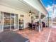 Covered outdoor patio featuring a brick floor, ceiling fan, and outdoor seating and view to the pool at 2601 Brookville Dr, Valrico, FL 33596