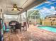 Screened patio with brick flooring, ceiling fan, outdoor furniture, and a swimming pool at 2601 Brookville Dr, Valrico, FL 33596
