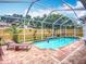 Inviting screened-in pool with brick patio, landscaping, and clear blue water at 2601 Brookville Dr, Valrico, FL 33596