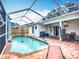 Screened-in pool area with brick patio, lounge chair, and access to a covered patio at 2601 Brookville Dr, Valrico, FL 33596