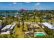 An aerial capture presenting a coastal neighborhood that features a community park, home with pool, and beautiful waterfront views at 3111 S De Bazan Ave, St Pete Beach, FL 33706