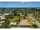 A tropical coastal neighborhood with a home, pool, mature trees, and tranquil waterways with open ocean in the background at 3111 S De Bazan Ave, St Pete Beach, FL 33706