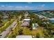 An aerial view showcasing a home with a pool, community park, canals and a bridge to city in the distance at 3111 S De Bazan Ave, St Pete Beach, FL 33706