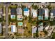 A vibrant aerial view showcasing several homes, some with pools, nestled amongst lush greenery in a coastal neighborhood at 3111 S De Bazan Ave, St Pete Beach, FL 33706