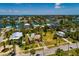 A beautiful neighborhood view with a cozy home, pool, mature palm trees, and stunning water views with bridge in the distance at 3111 S De Bazan Ave, St Pete Beach, FL 33706