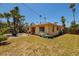Exterior view of cozy home with a patio and ample yard space surrounded by tropical landscaping at 3111 S De Bazan Ave, St Pete Beach, FL 33706