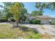 View of a single-Gathering home with an attached garage and shade trees at 3256 Adrian Ave, Largo, FL 33774