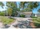 Single-Gathering home with an attached garage, concrete driveway, and yard with trees at 3256 Adrian Ave, Largo, FL 33774