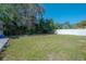 Large backyard featuring a sturdy white fence, a deck and mature trees at 3258 Adrian Ave, Largo, FL 33774