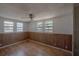 Bright bedroom featuring three windows, wood floors, and a classic ceiling fan at 3258 Adrian Ave, Largo, FL 33774