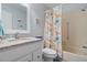 This bathroom features a tub-shower combo, a granite sink, and colorful decor at 340 Causeway Blvd # 104, Dunedin, FL 34698