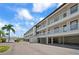 Low angle view of the exterior of the building featuring private balconies and covered parking at 340 Causeway Blvd # 104, Dunedin, FL 34698