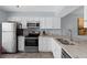 Efficient kitchen featuring granite countertops, stainless appliances, and ample white cabinetry at 340 Causeway Blvd # 104, Dunedin, FL 34698