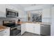 Efficient kitchen featuring granite countertops, stainless appliances, and convenient pass-through at 340 Causeway Blvd # 104, Dunedin, FL 34698