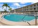 Beautiful community pool with lounge chairs, steps for easy access and beautiful landscaping at 340 Causeway Blvd # 104, Dunedin, FL 34698