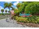 Frenchy's Outpost Bar & Grill sign with a fish statue and lush landscaping in a tropical setting at 340 Causeway Blvd # 104, Dunedin, FL 34698