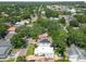 Aerial view of a white two-story home surrounded by trees, with neighboring houses and town in the background at 3405 W Palmira Ave, Tampa, FL 33629