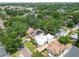 Aerial view showcases a white home surrounded by lush greenery, other homes, and a glimpse of the cityscape at 3405 W Palmira Ave, Tampa, FL 33629