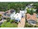 Aerial view of a two-story white home with a unique architecture, featuring a brick pathway and lush landscaping at 3405 W Palmira Ave, Tampa, FL 33629