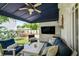 Relax on the back porch, which features a ceiling fan and a large television, overlooking the backyard at 3405 W Palmira Ave, Tampa, FL 33629
