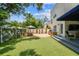 The turf backyard is ready for entertaining with an outdoor kitchen, covered patio, and dining area at 3405 W Palmira Ave, Tampa, FL 33629