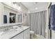 Bright bathroom featuring double sink vanity, shower, and toilet at 3405 W Palmira Ave, Tampa, FL 33629