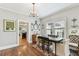 Elegant dining room with a chandelier, hardwood floors, and a view into the kitchen at 3405 W Palmira Ave, Tampa, FL 33629