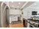 Well-lit kitchen with white cabinets, stainless steel appliances, granite counters, gas range, and farmhouse sink at 3405 W Palmira Ave, Tampa, FL 33629