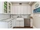 Bright and airy kitchen with white cabinets, granite countertops, farmhouse sink, and stainless steel dishwasher at 3405 W Palmira Ave, Tampa, FL 33629