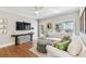 A cozy living room featuring white couches, hardwood flooring, and a ceiling fan at 3405 W Palmira Ave, Tampa, FL 33629