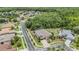 Aerial view of home in a quiet neighborhood showcasing the screened pool, mature trees, and manicured lawn at 3656 Kalanchoe Pl, Wesley Chapel, FL 33544