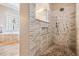Modern shower with textured tile walls and a rain showerhead in a beautifully designed bathroom at 3656 Kalanchoe Pl, Wesley Chapel, FL 33544