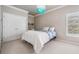 This bedroom features a charming turquoise chandelier, built-in shelving, and a double door closet for ample storage at 3656 Kalanchoe Pl, Wesley Chapel, FL 33544