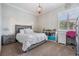 Charming bedroom with neutral colors, decorative lighting, and a cozy study nook with a pink chair at 3656 Kalanchoe Pl, Wesley Chapel, FL 33544