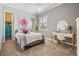 Cozy bedroom with a metal frame bed, bright decor, and a vanity area at 3656 Kalanchoe Pl, Wesley Chapel, FL 33544