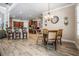 Open dining area showcases wood-look tile flooring, chandelier, and breakfast bar with stone accents at 3656 Kalanchoe Pl, Wesley Chapel, FL 33544