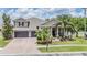 Charming home featuring a well-manicured lawn, mature palm trees, a two-car garage, and beautiful landscaping at 3656 Kalanchoe Pl, Wesley Chapel, FL 33544