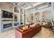 Cozy living room featuring a stone fireplace, coffered ceiling, built-in shelves, and a comfortable leather sofa at 3656 Kalanchoe Pl, Wesley Chapel, FL 33544