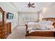 Bright main bedroom features plantation shutters, tray ceiling, ceiling fan, and access to outdoor patio at 3656 Kalanchoe Pl, Wesley Chapel, FL 33544