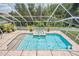 Resort-style pool area with hot tub, surrounded by lush landscaping, and enclosed in a screened lanai at 3656 Kalanchoe Pl, Wesley Chapel, FL 33544