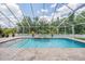 Backyard pool with water features, mature plants, and an enclosed screened enclosure at 3656 Kalanchoe Pl, Wesley Chapel, FL 33544