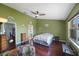Bright bedroom boasts en suite bath, walk-in closet, ceiling fan, and hardwood floors at 3834 102Nd N Pl, Clearwater, FL 33762