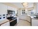 Updated kitchen boasts stainless appliances, white cabinets, tile backsplash, and modern lighting at 3834 102Nd N Pl, Clearwater, FL 33762