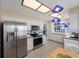 Renovated kitchen with stainless steel appliances, white cabinets, tile backsplash, and casual dining area at 3834 102Nd N Pl, Clearwater, FL 33762