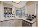 Kitchen with white cabinetry, updated appliances, tile backsplash, and natural light at 3834 102Nd N Pl, Clearwater, FL 33762