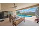 Covered patio with dining set offers views of the beautiful pool and screened enclosure at 3834 102Nd N Pl, Clearwater, FL 33762