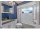 Full bathroom with blue accent wall, modern vanity and shower/tub combo at 3968 Orchard Hill Cir, Palm Harbor, FL 34684