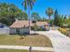 Charming home featuring well-manicured landscaping, palm trees, and a long driveway at 3968 Orchard Hill Cir, Palm Harbor, FL 34684