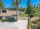 Exterior view of home with side yard access, American flag and Palm Tree at 3968 Orchard Hill Cir, Palm Harbor, FL 34684