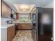 Functional kitchen with wooden cabinets, stainless steel appliances, and tiled flooring at 3968 Orchard Hill Cir, Palm Harbor, FL 34684